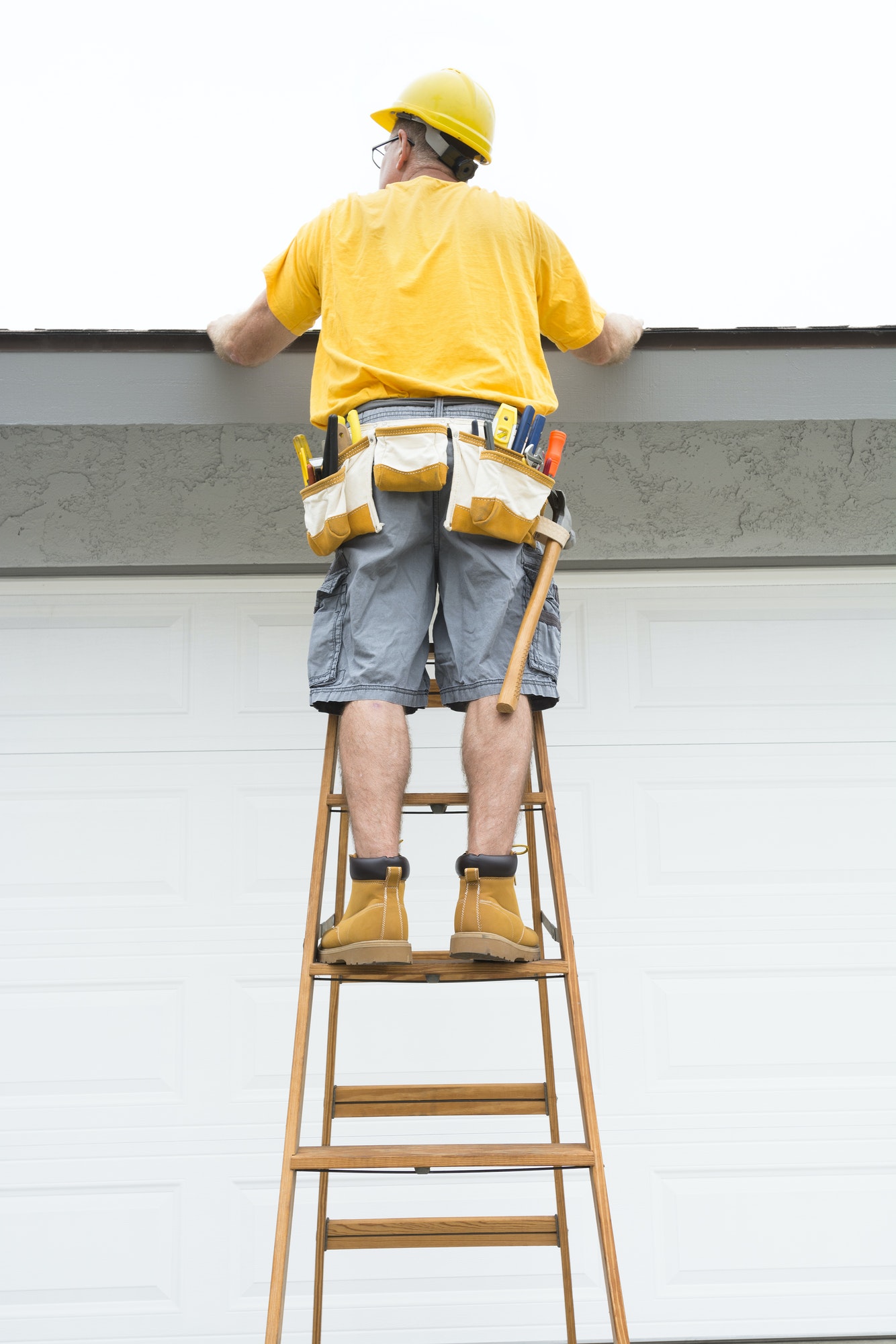 Contractor standing on ladder